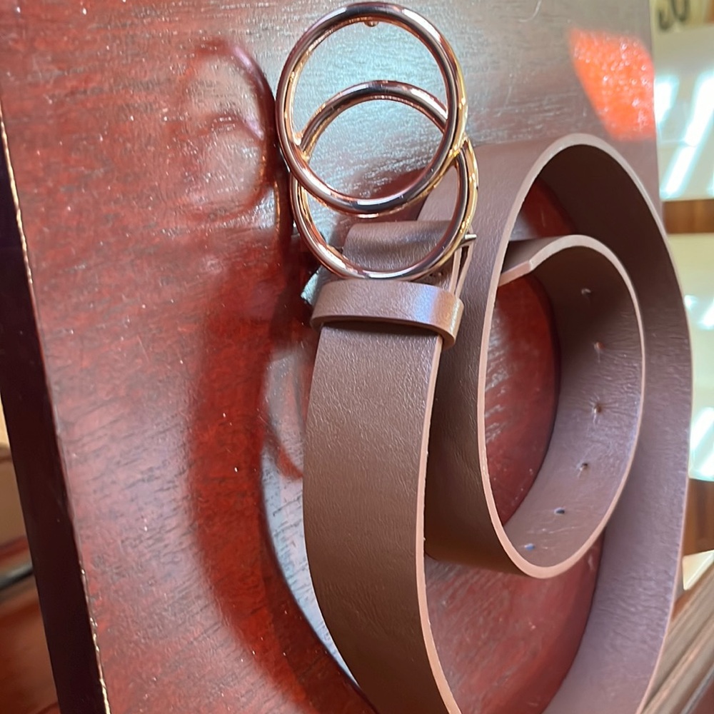 Woman’s brown belt with copper colored buckle